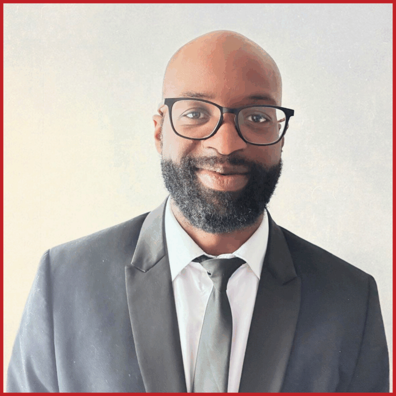 Michel Tume: UASA Board Member, smiling to camera wearing a smart suit