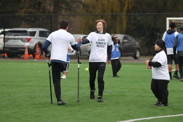 Adaptive soccer players of all disabilities celebrate after scoring a goal