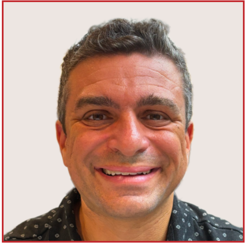 Marc Burkom smiles to camera for a professional headshot